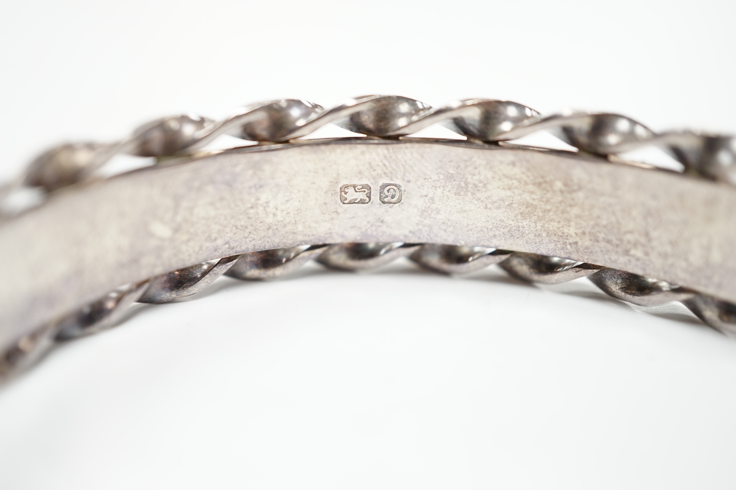 An Elizabeth II bright cut engraved silver hinged bangle, with spiral borders, Birmingham, 1978.